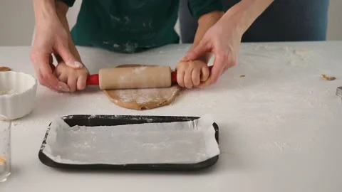 Child rolls the dough for gingerbread. Son and mother make christmas gingerbread Stock Footage 131046464
