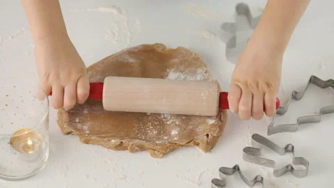 Child rolls the dough for gingerbread. Son and mother make christmas gingerbread Stock Footage 131776953