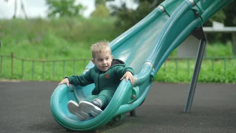 The child rolls down a children&amp;#039;s slide. Video stock 344811487