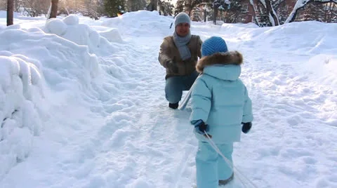 Child rolls the sled yourself to meet his father Stock Footage 25354563
