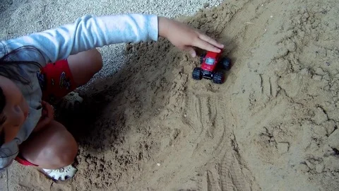 A child rolls a small typewriter in the sandbox Stock Footage 78050387