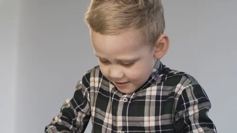A child rolls a white piece of plasticine on a white table Stock Footage 124941654