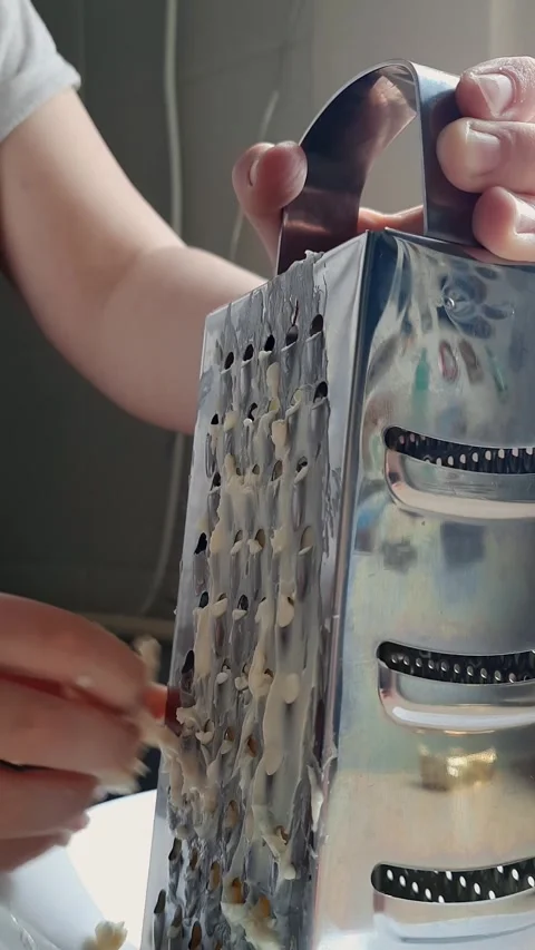 Child rubs soft cheese on kitchen grater at home. Simple video recipe. Stock Footage 241326625