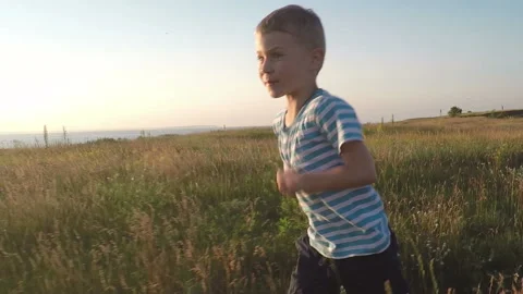 Child run in the field at sunset. Slowmotion Stock-Footage 89756880