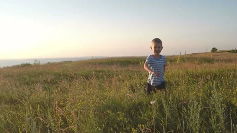 Child run in the field at sunset. Slowmotion Stock Footage 90519051
