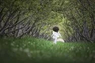 A Child Running Along A Natural Woodland Tunnel With Tree Branches Forming An Stock Photos