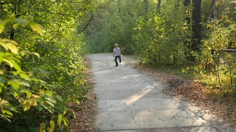 Child running along a path in a park Vidéo 67829508