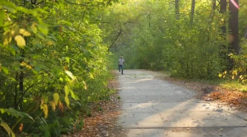 Child running along a path in a park Vidéo 67829740