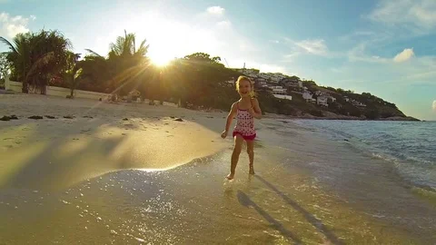 Child running along the surf at sunset. Slow motion Stock Footage 72845148