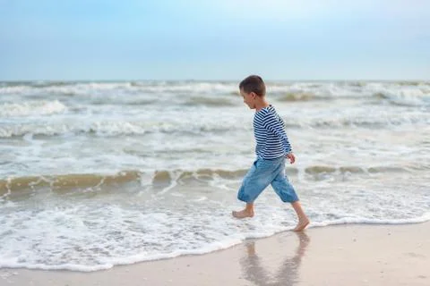 Child running on the beach. Summer vacation. happy kid playing on beach at th Foto stock