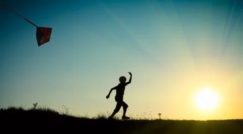 Child running with a kite Stock Photos