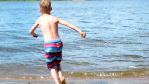 A child running into the river. Slow motion. Stock Footage 202717615