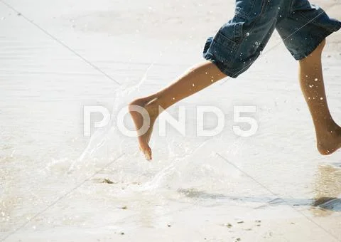 Child Running In Surf At The Beach