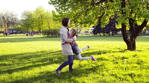 Child running through the field into her mother's open arms and hugging her Stock Footage 75709078