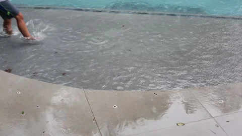 Child running through water pool step puddle water splash video Stock Footage 135849350