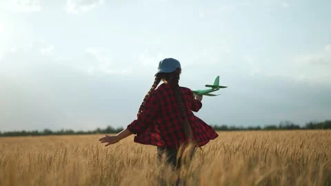 Child running in wheat field. Kid holding toy plane dreams travel. Happy child Stock Footage 317008161