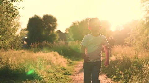 Child runs along path in park in sun. Happy family child concept. Child boy runs Stock Footage 264595280