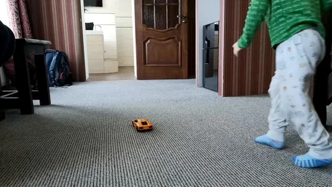 The child runs behind the car on the remote control. Concept of happy family, lo Video stock 101376241