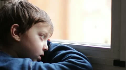 Child sad and lonely looking through window Video stock 21050153