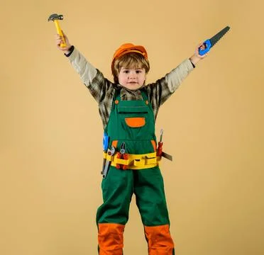 Child in safety helmet and toolbelt with saw and hammer. Work with tools. Boy Stock Photos