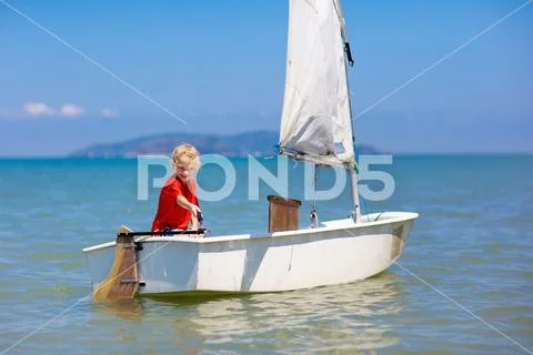 Child sailing. Kid learning to sail on sea yacht. Stock Photos