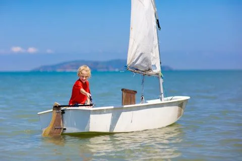 Child sailing. Kid learning to sail on sea yacht. Stock Photos