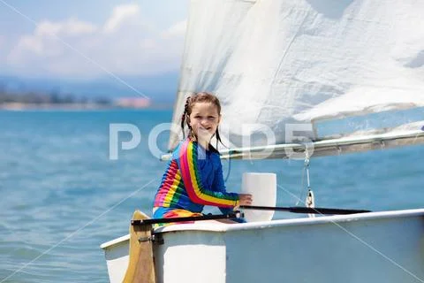 Child sailing. Kid learning to sail on sea yacht. Stock Photos
