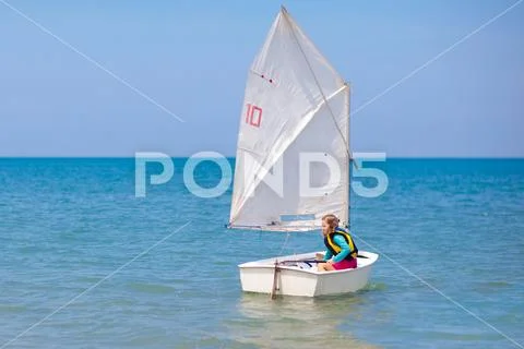 Child sailing. Kid learning to sail on sea yacht. Stock Photos