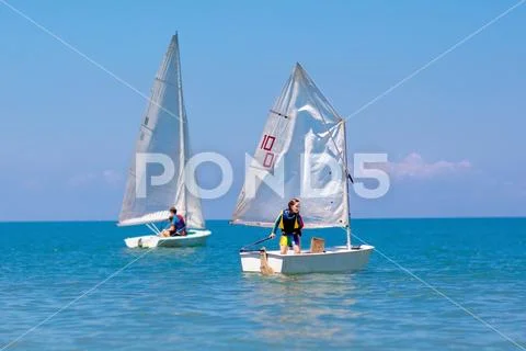 Child sailing. Kid learning to sail on sea yacht. Stock Photos