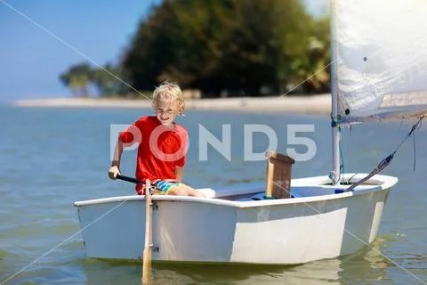 Child sailing. Kid learning to sail on sea yacht. Stock Photos
