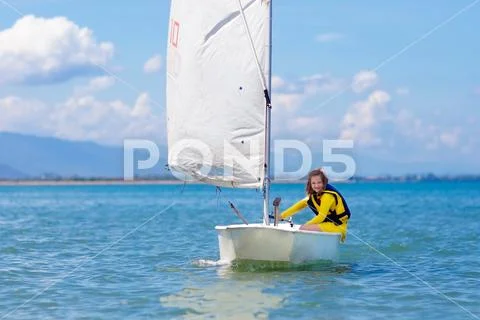 Child sailing. Kid learning to sail on sea yacht. Stock Photos