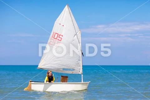 Child sailing. Kid learning to sail on sea yacht. Stock Photos