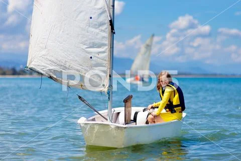 Child sailing. Kid learning to sail on sea yacht. Stock Photos