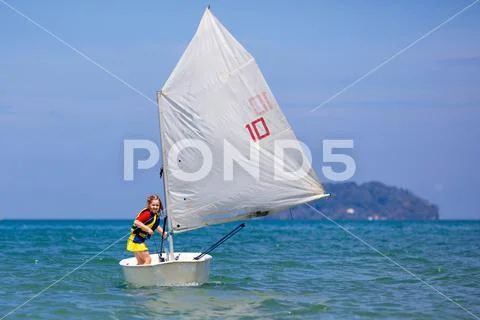 Child sailing. Kid learning to sail on sea yacht. Stock Photos