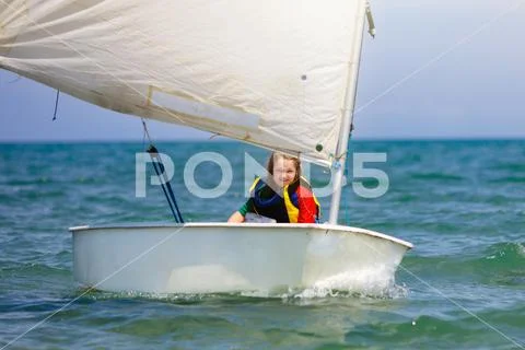 Child sailing. Kid learning to sail on sea yacht. Stock Photos