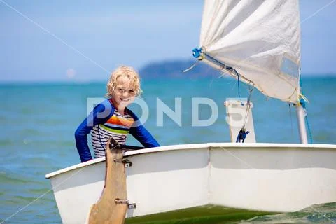 Child sailing. Kid learning to sail on sea yacht. Stock Photos