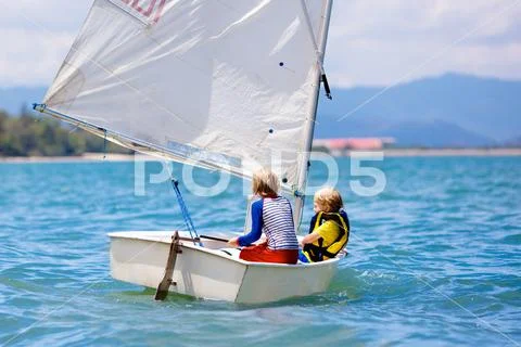 Child sailing. Kid learning to sail on sea yacht. Stock Photos