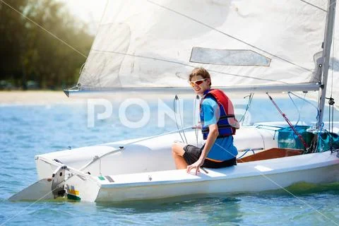 Child sailing. Kid learning to sail on sea yacht. Stock Photos