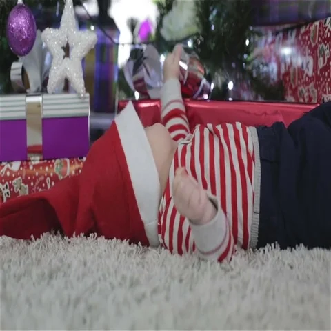 Child in a Santa hat lying on the floor in the new year background. Stock Footage 69428959