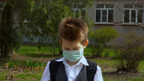 Child in school suit put on wireless headphone in his ears, listening music.  Stock-Footage 127834916