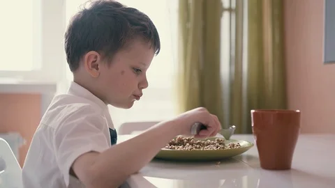Child in school uniforms, breakfasts before going to school. Stock Footage 105096661