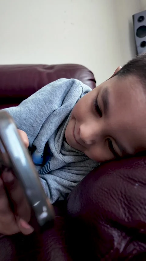 Child Screen Time, Young Boy Using Smartphone On Sofa. vertical video Stock Footage 334451885