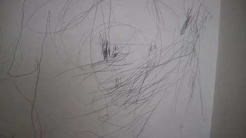Child scribbling on a white wall, messy creative drawing by a young artist,.. Stock Photos