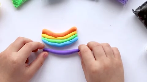 The child sculpts makes a rainbow from plasticine. Children's creativity. Stock Footage 241638857