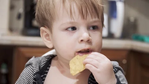 Child seat and eats corn chips 動画素材 126313803