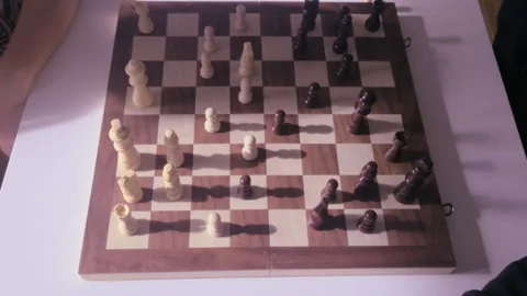 Child shadow cast on chessboard during strategic thinking moment in top down Stock Footage 331277259