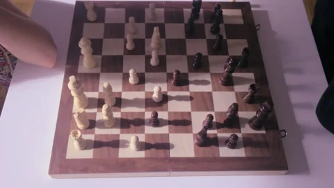 Child shadow cast on chessboard during strategic thinking moment in top down Stock Footage 331765856