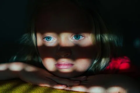 Child in Shadow Light with Thoughtful Expression Stock Photos
