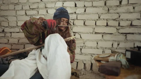Child Sharpens Wood with Cutlass in Cold Shelter Kitchen Corner Video stock 327019815