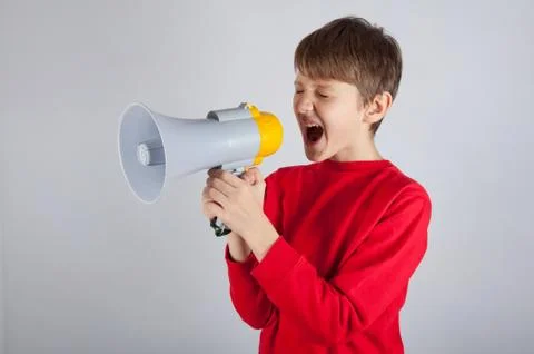 Child shouting in megaphone on bright background Stock Photos